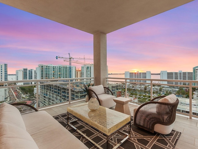 balcony at dusk featuring a view of city