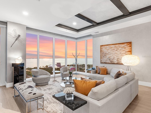 living area with beam ceiling, coffered ceiling, wood finished floors, a wall of windows, and baseboards