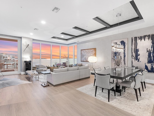 dining space with a wall of windows, visible vents, light wood-type flooring, and coffered ceiling