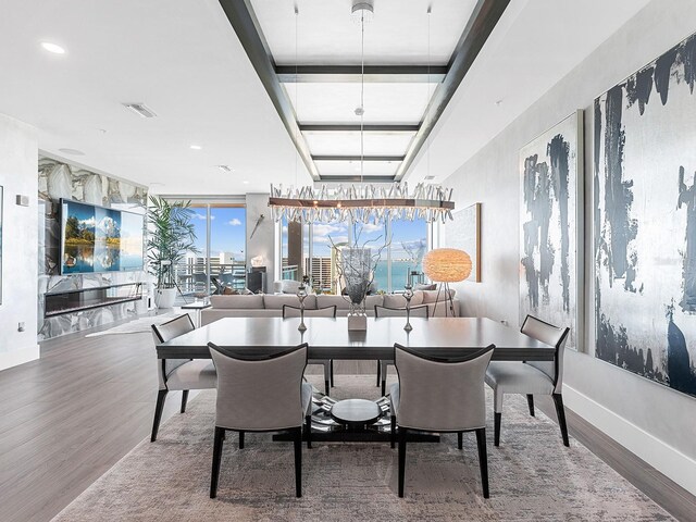 dining area featuring visible vents, baseboards, and wood finished floors