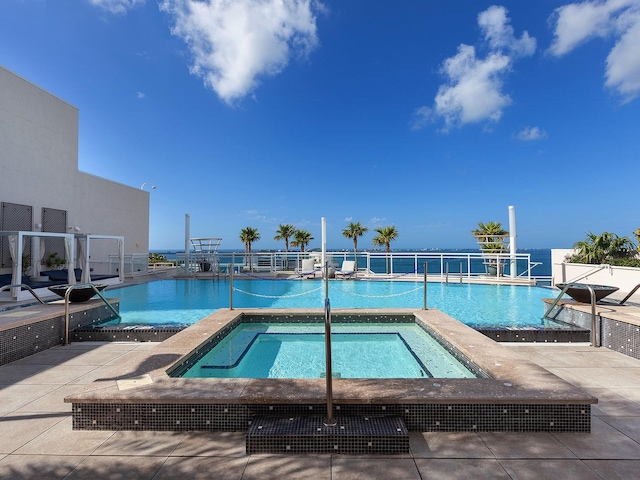 pool with a patio and a community hot tub