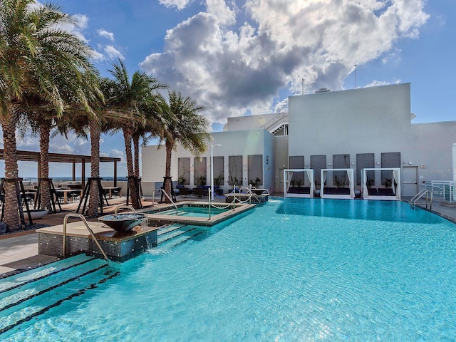 community pool with a patio and a hot tub