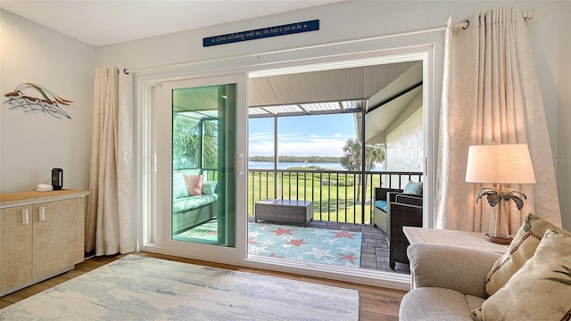 doorway to outside with wood finished floors and a water view