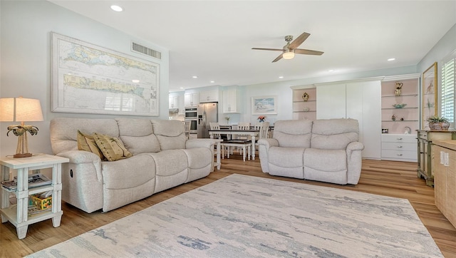 living area featuring light wood-type flooring, visible vents, a ceiling fan, and recessed lighting