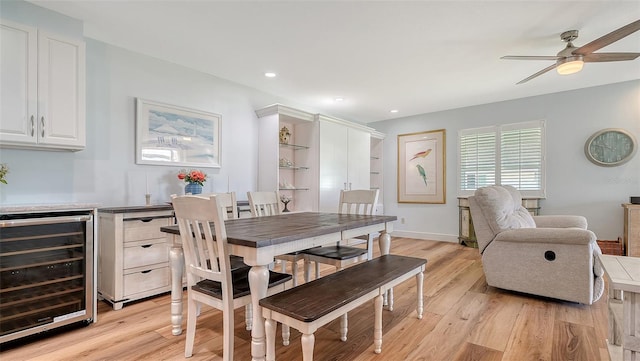 dining area featuring light wood finished floors, baseboards, wine cooler, recessed lighting, and a ceiling fan