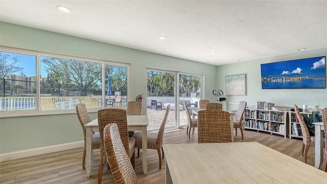 dining space with recessed lighting, wood finished floors, baseboards, and a textured ceiling