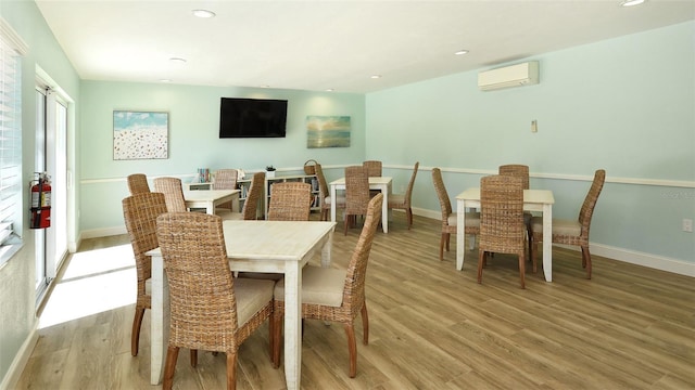 dining area with recessed lighting, light wood-style flooring, and a wall unit AC