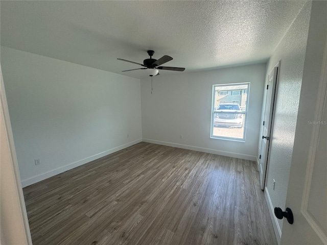 spare room with a ceiling fan, a textured ceiling, baseboards, and wood finished floors