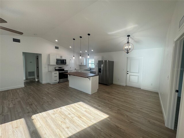 kitchen featuring appliances with stainless steel finishes, a center island, open floor plan, and visible vents