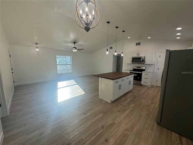 kitchen with lofted ceiling, wood counters, a kitchen island, open floor plan, and stainless steel appliances