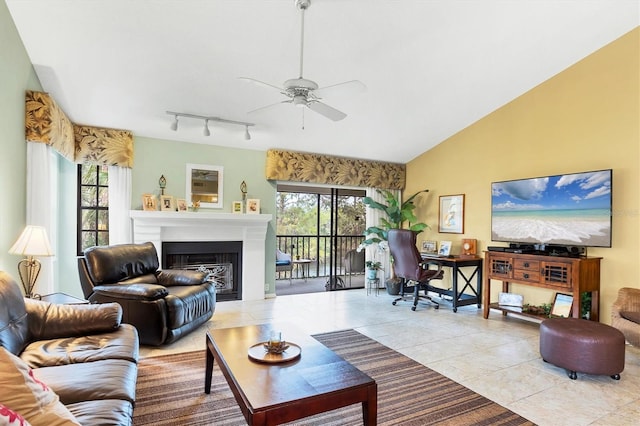 tiled living room featuring plenty of natural light, a fireplace, vaulted ceiling, and a ceiling fan