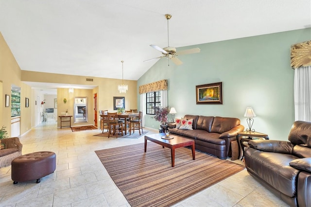 living area with high vaulted ceiling, visible vents, baseboards, and ceiling fan with notable chandelier