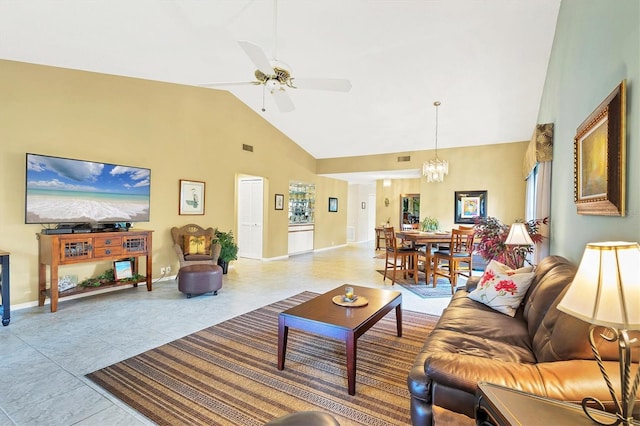 tiled living room featuring baseboards, high vaulted ceiling, and ceiling fan with notable chandelier