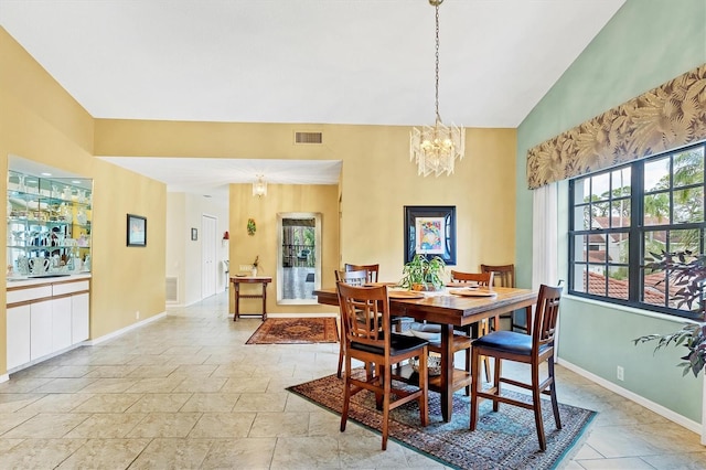 dining area with baseboards, high vaulted ceiling, visible vents, and a notable chandelier