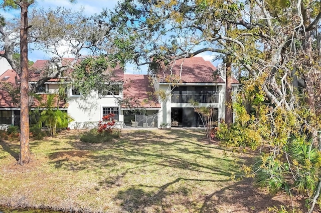 back of house with a lawn and stucco siding