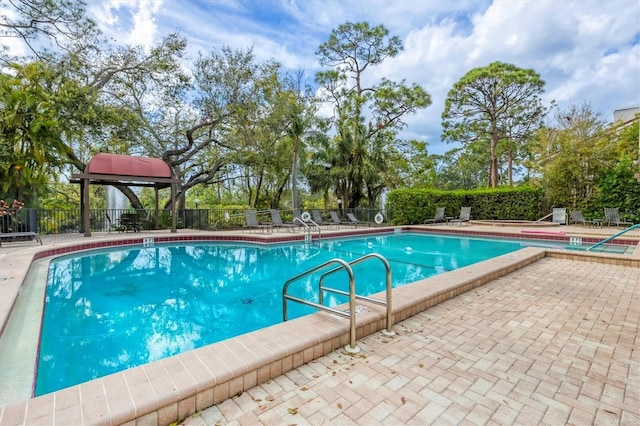 pool with fence and a patio