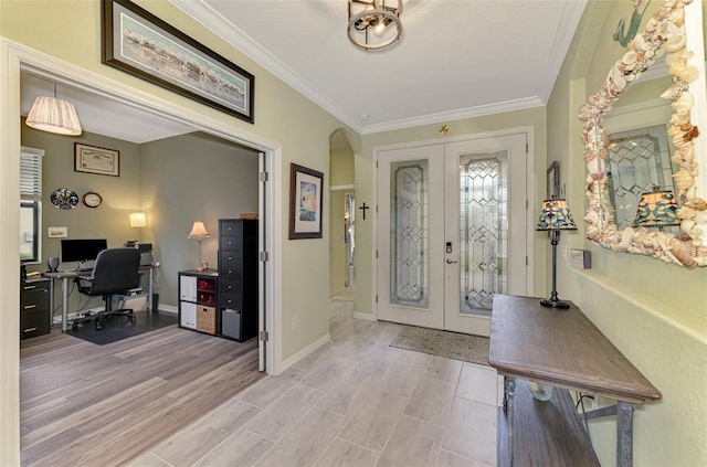 entrance foyer with ornamental molding, french doors, arched walkways, and light wood-style floors