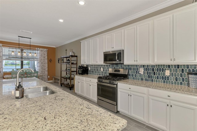 kitchen featuring stainless steel appliances, backsplash, ornamental molding, white cabinets, and a sink