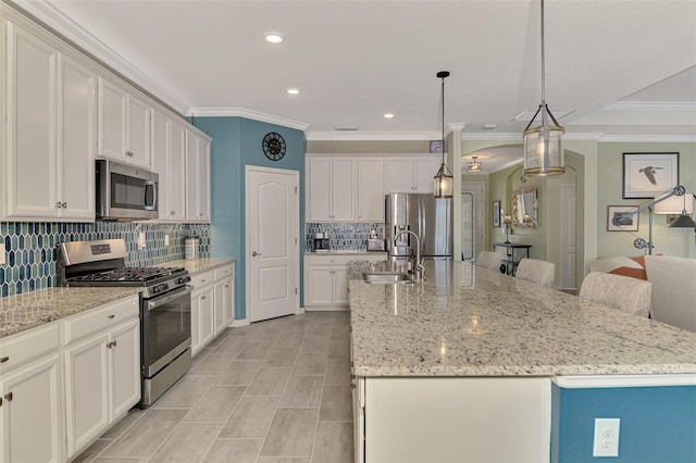 kitchen featuring arched walkways, a sink, white cabinetry, appliances with stainless steel finishes, and a center island with sink