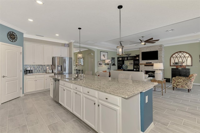 kitchen with a fireplace, a sink, visible vents, white cabinets, and appliances with stainless steel finishes