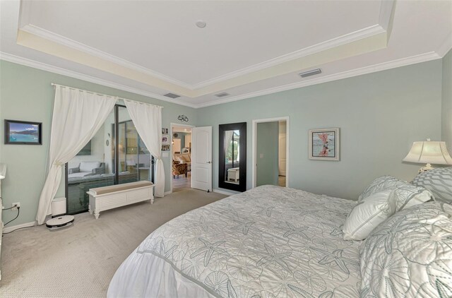 bedroom with carpet, visible vents, and a tray ceiling