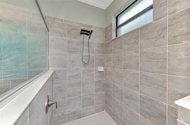 bathroom featuring a tile shower and crown molding