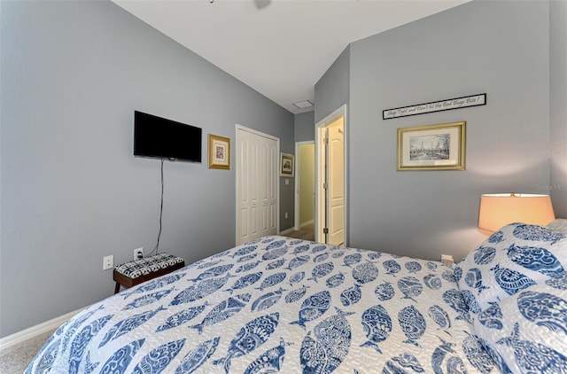 carpeted bedroom featuring lofted ceiling, a closet, and baseboards