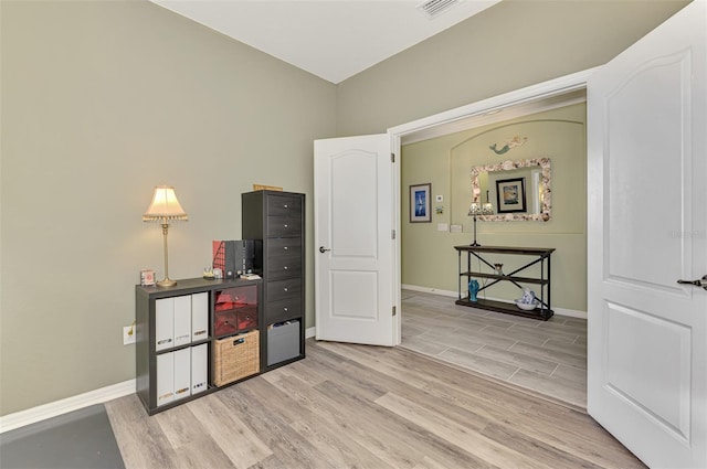 interior space featuring light wood finished floors, visible vents, and baseboards