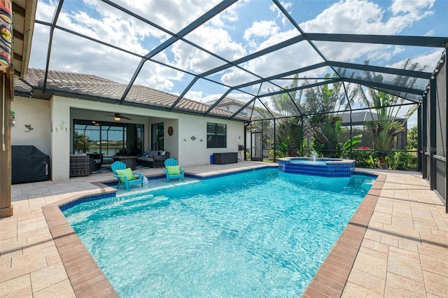 view of pool featuring a patio, glass enclosure, an outdoor hangout area, a pool with connected hot tub, and a ceiling fan