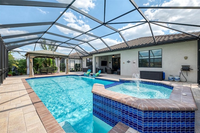 view of pool with ceiling fan, a patio, glass enclosure, and a pool with connected hot tub