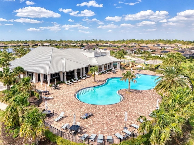 community pool featuring fence and a patio