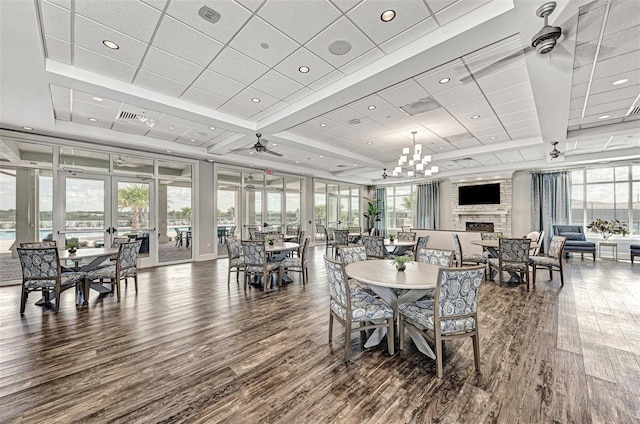 dining area with a wealth of natural light, visible vents, a fireplace, and wood finished floors