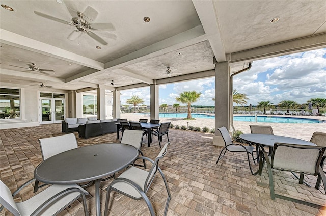 view of patio / terrace with a community pool, an outdoor hangout area, french doors, and outdoor dining space