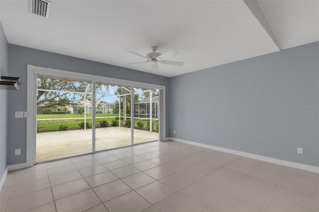 spare room featuring a ceiling fan, tile patterned flooring, visible vents, and baseboards