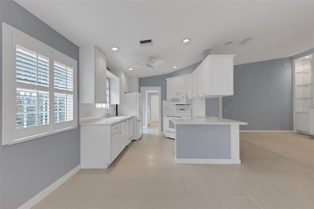 kitchen featuring white appliances, a sink, visible vents, baseboards, and light countertops