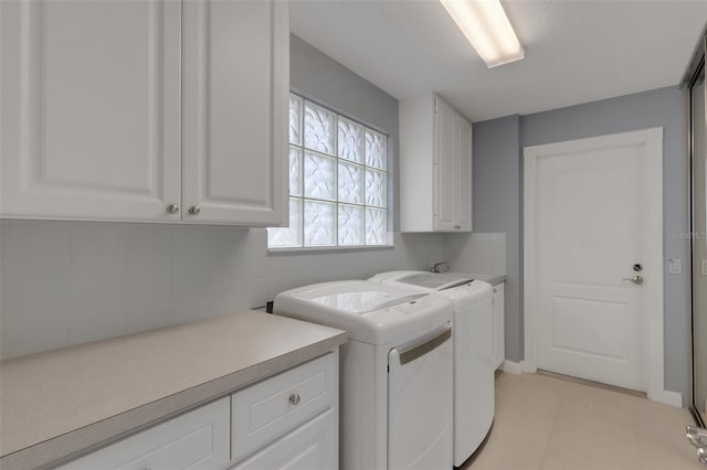 laundry area with cabinet space, light tile patterned floors, and washer and dryer