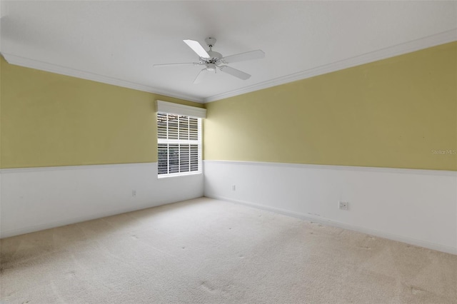 carpeted empty room featuring ceiling fan, ornamental molding, and baseboards