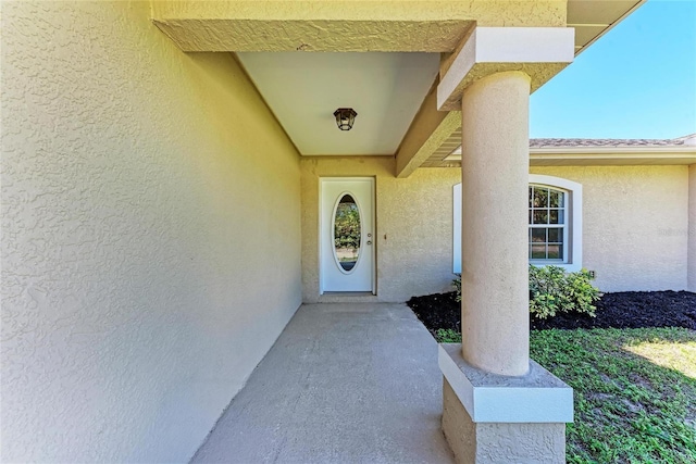 entrance to property featuring stucco siding