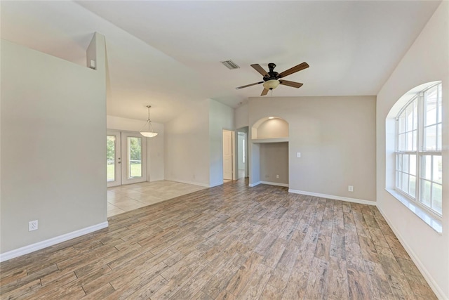 unfurnished room featuring lofted ceiling, visible vents, a ceiling fan, wood finished floors, and baseboards