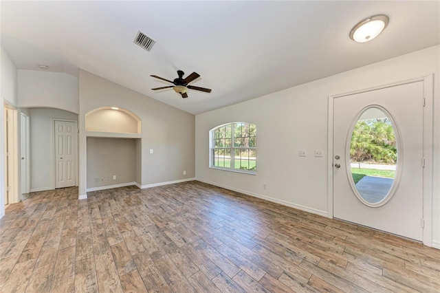 foyer entrance with a ceiling fan, lofted ceiling, visible vents, and wood finished floors