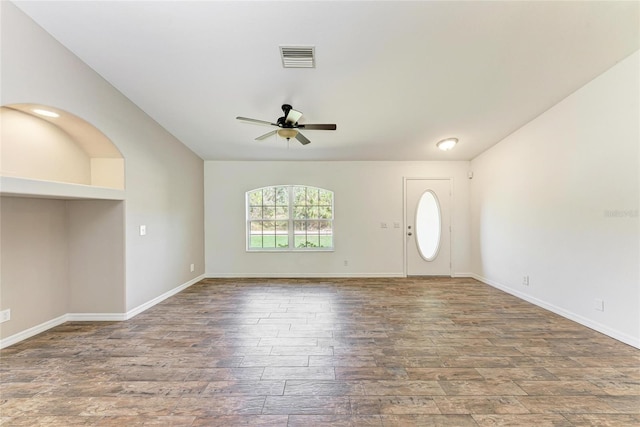 interior space featuring a ceiling fan, baseboards, visible vents, and wood finished floors