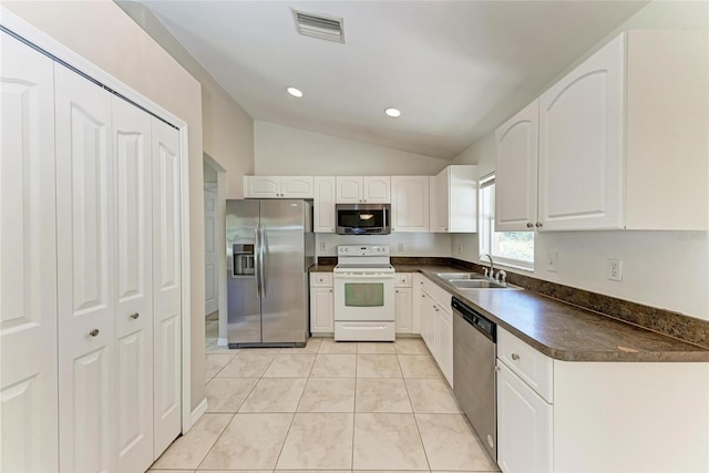 kitchen with visible vents, dark countertops, stainless steel appliances, white cabinetry, and a sink