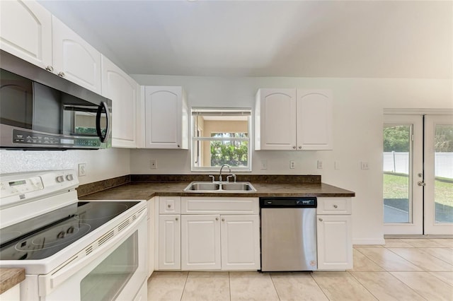 kitchen with a sink, dishwasher, dark countertops, and electric stove