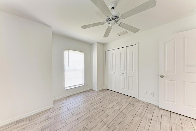 unfurnished bedroom with light wood-style floors, a closet, visible vents, and baseboards