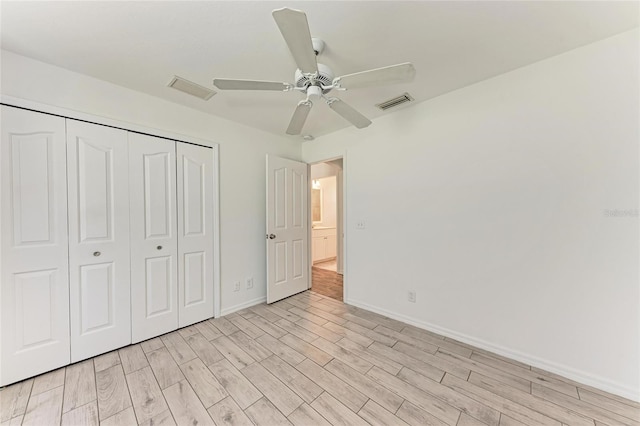 unfurnished bedroom featuring baseboards, visible vents, ceiling fan, light wood-style floors, and a closet