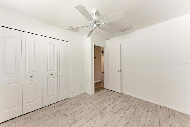 unfurnished bedroom featuring light wood-style floors, a closet, visible vents, and baseboards