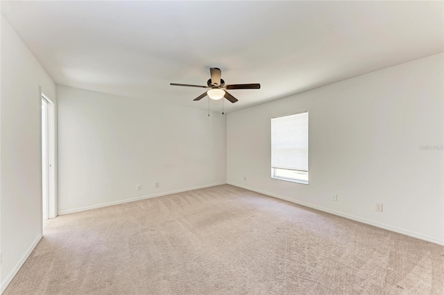 unfurnished room with light colored carpet, ceiling fan, and baseboards