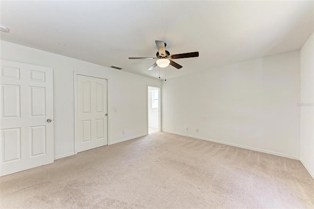 interior space featuring a ceiling fan, light colored carpet, visible vents, and baseboards