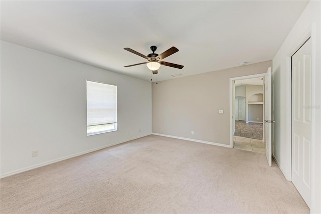 unfurnished bedroom featuring light carpet, ceiling fan, and baseboards