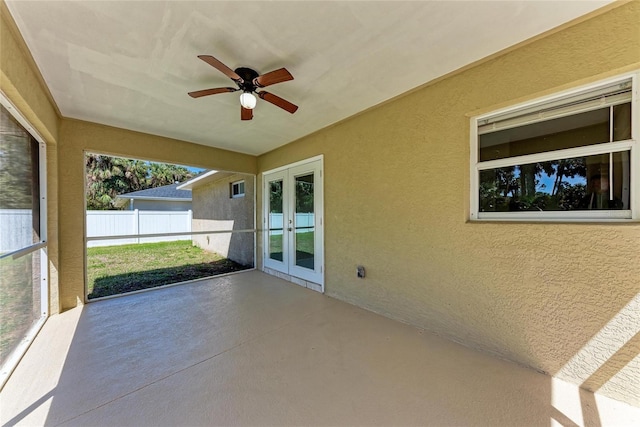 unfurnished sunroom with ceiling fan and french doors